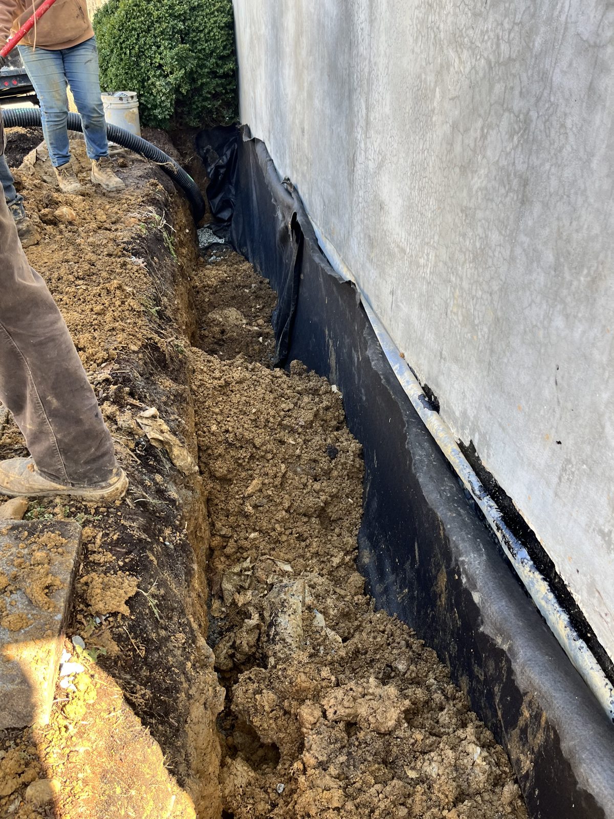 Rubberized waterproofing membrane applied to the foundation wall